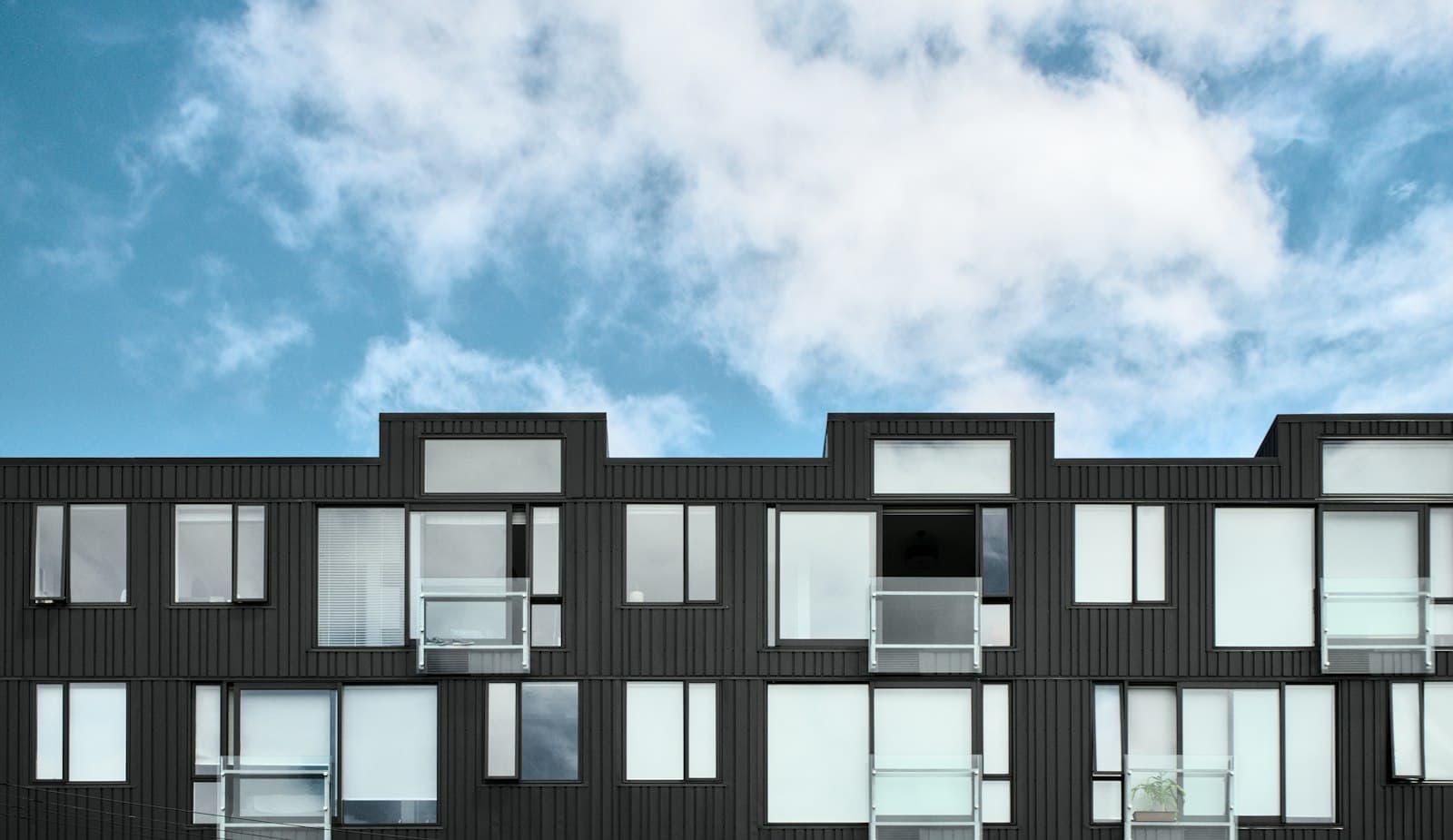 Illustrative photo of a modern apartment building with balconies, not a photograph of the AVAMAR project